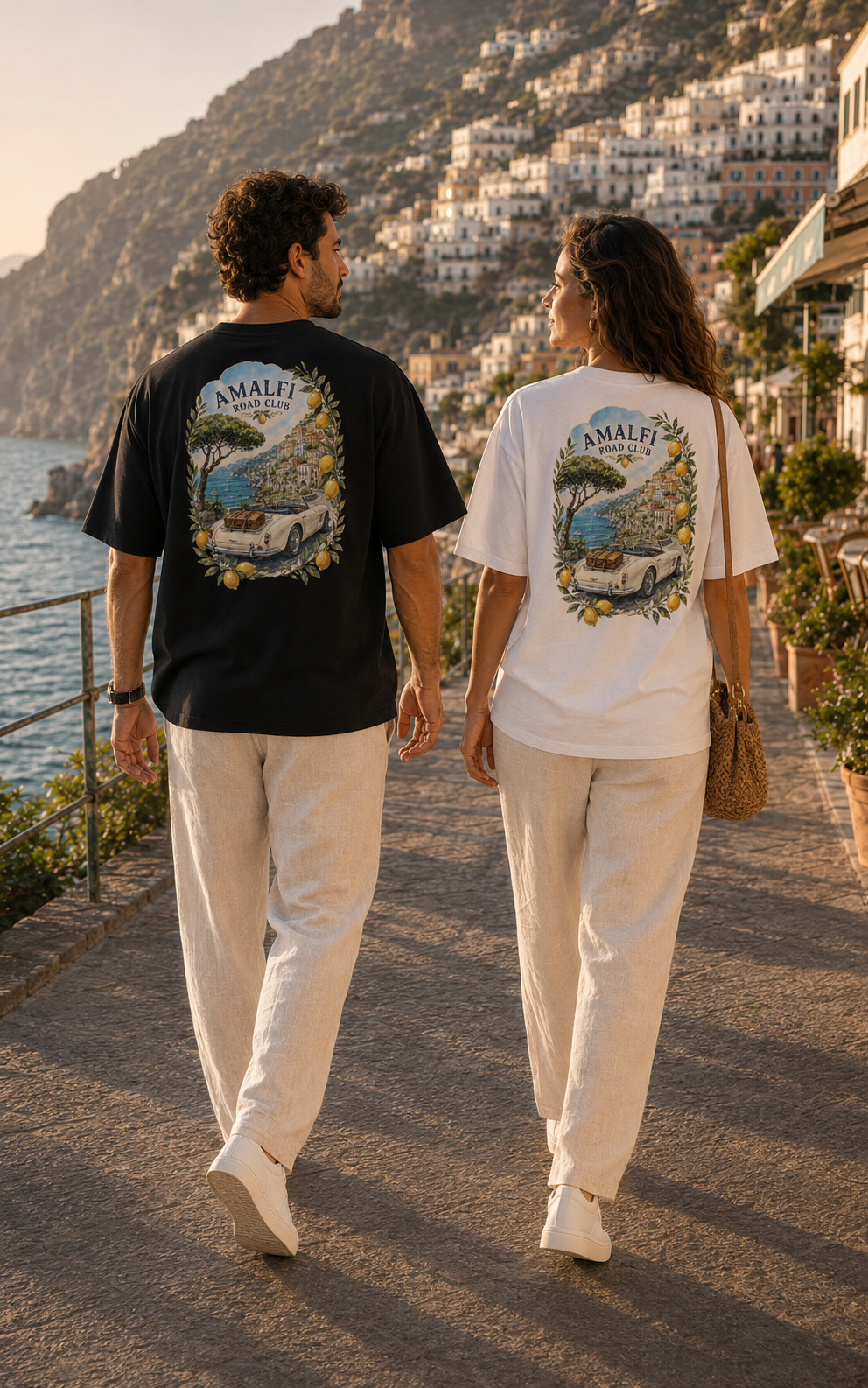 Couple wearing Amalfi Road Club T-shirts with large Amalfi Coast back print in Positano