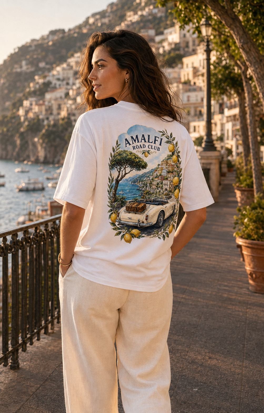 1. Woman wearing white Amalfi Road Club T-shirt with large vintage Amalfi Coast car and lemon back print