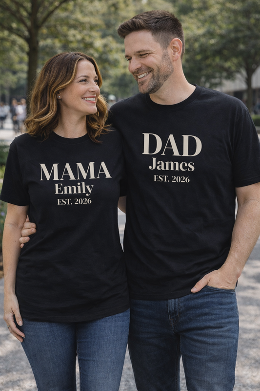 Happy couple wearing matching personalized t-shirts with “Mama Emily Est. 2026” and “Dad James Est. 2026” text, custom name shirts for parents.