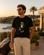 Man wearing a black My Keepsake T-shirt with a stylish teddy bear carrying a champagne bucket.