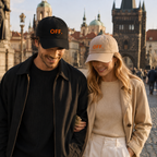 Young couple wearing black and stone OFF embroidered caps while walking in Prague.
