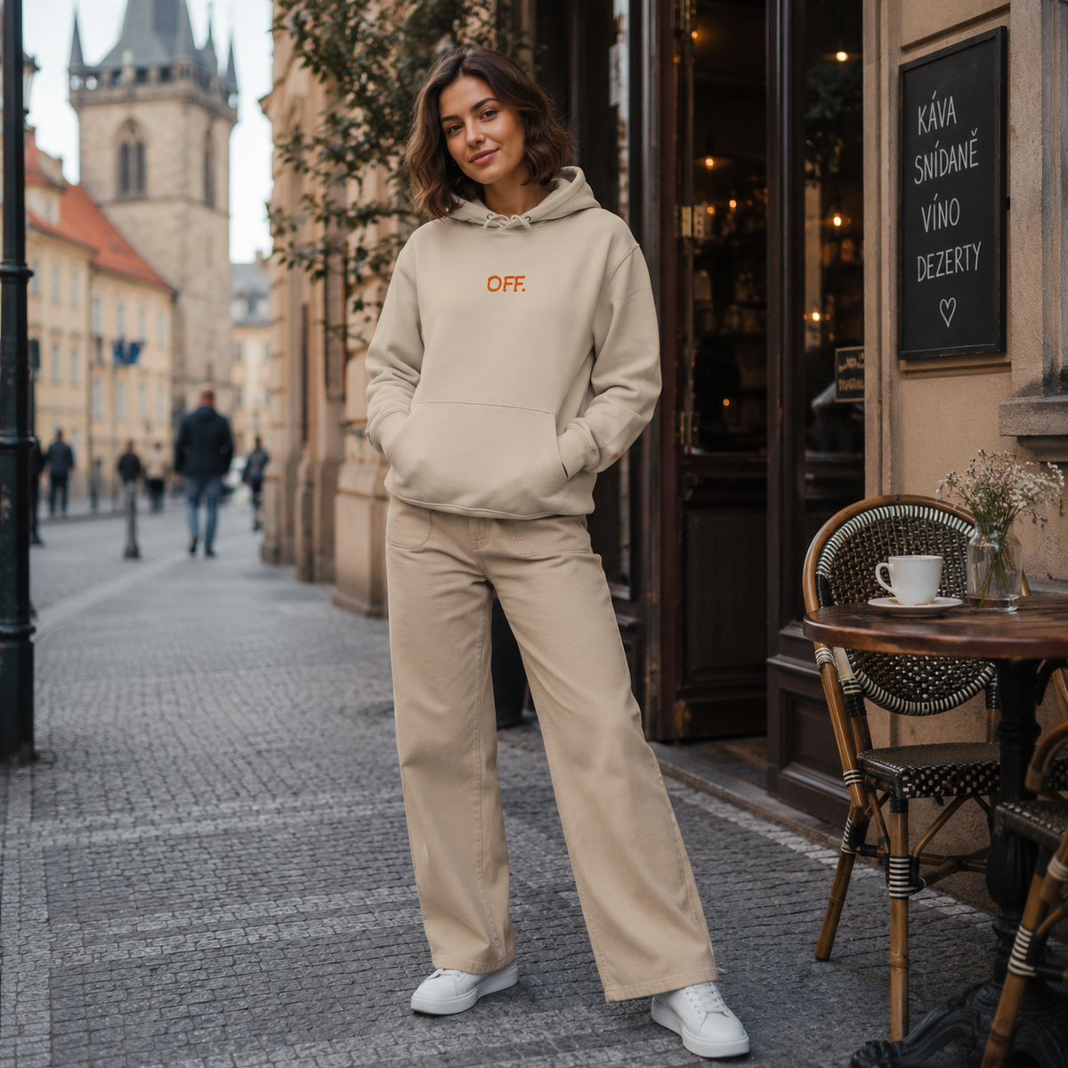 Young woman wearing a desert dust organic cotton hoodie with orange OFF embroidery